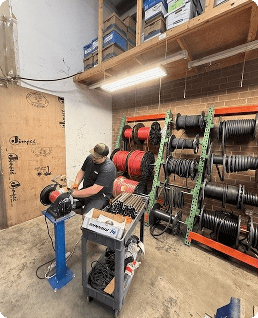Technician handling coiled cables in workshop