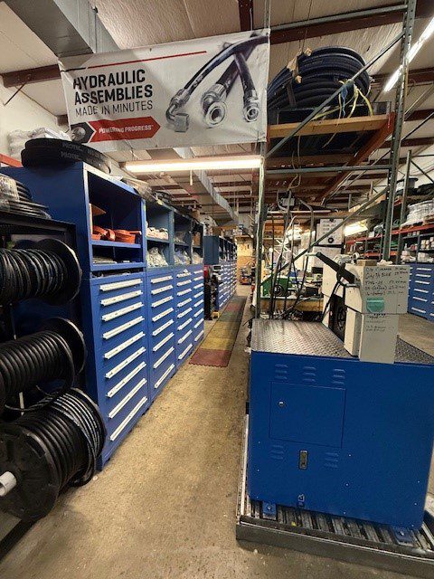 Interior aisle of an automotive parts store with shelves and tires.